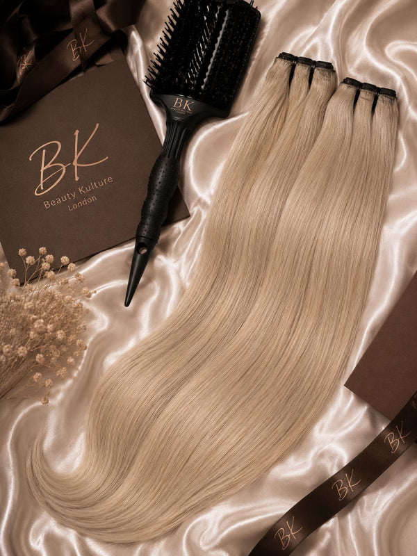 Hair extensions and a hairbrush on satin fabric with 'BK Beauty Kulture London' branding.